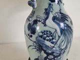 a blue and white vase with a lamp on a table