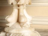 a white marble pedestal with a vase on top of it