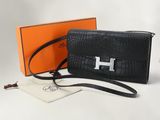 un sac à main noir orné d'un logo « h » argenté sur le devant