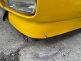 a close up of a yellow car parked on the side of the road