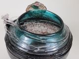 a glass jar with a ring inside of it on a table