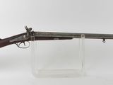 un vieux fusil au canon en bois, posé sur un socle transparent