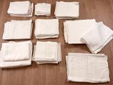 de nombreuses serviettes blanches disposées sur un parquet