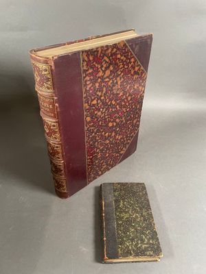 un vieux livre posé à côté d'un petit livre sur une table