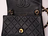 a close up of a black purse with a chain around it