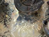 a silver plate with a silver tea pot on top of it