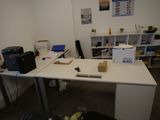 un bureau blanc sur lequel est posé un ordinateur portable, dans une pièce