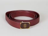 un gros plan d'une ceinture rouge avec une boucle dorée