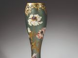 an ornate vase with a floral design on it sitting on a table