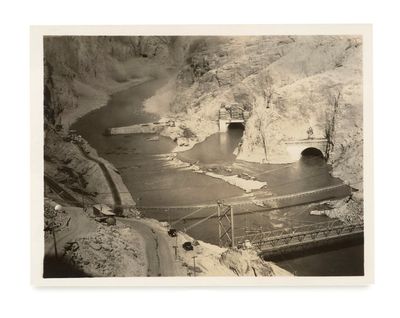 a black and white photo of a river and a bridge