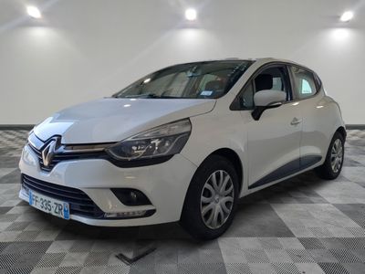 une voiture blanche est garée dans une pièce au sol à carreaux