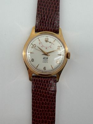 une image d'un gros plan d'une montre-bracelet sur une surface blanche