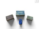 plusieurs dés en marbre bleu et vert posés sur une surface blanche