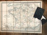une carte de la France accrochée au mur, à côté d'un portefeuille
