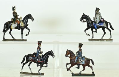 several figurines of men riding horses on display in a glass case