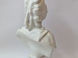 white marble bust of a woman with a turban on her head