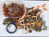 un récipient en plastique contenant des bijoux divers et une paire de ciseaux