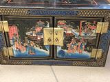 a black box with a painting on it sitting on the floor