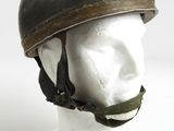 un vieux casque posé sur la tête d'un mannequin, sur une surface blanche