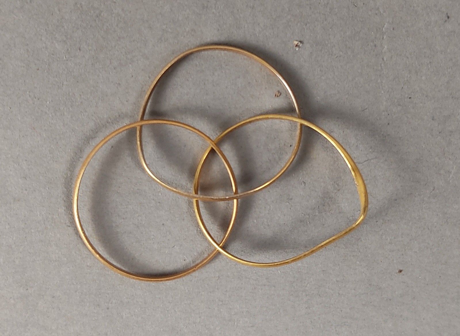 Une bague en or jaune 750mm (18k), à trois anneaux enchâssés…