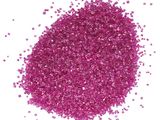 un gros plan sur un tas de paillettes roses sur fond blanc