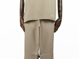 Le mannequin porte un costume beige et un pantalon beige.