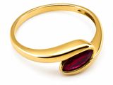 gros plan d'une bague en or avec une pierre rouge
