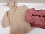 two sweaters that are sitting on a table