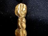 une pépite d'or et une pièce de monnaie sur un fond noir