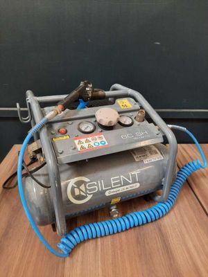 an air compressor sitting on top of a wooden table next to a blue hose