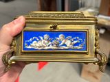 Quelqu'un tient une boîte bleue et dorée décorée d'anges.