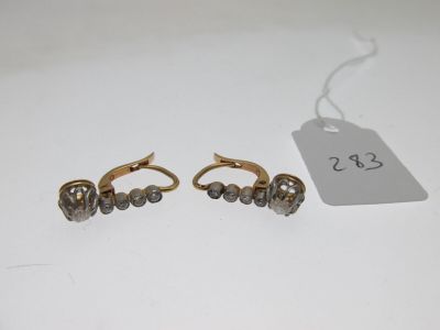 a pair of gold and diamond earrings