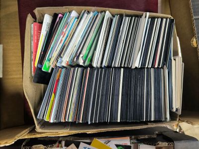une boîte remplie de CD et des CD posés par terre