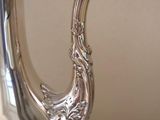 a silver tea pot sitting on a white table