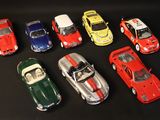 several toy cars are lined up in a row on a black surface
