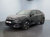 une voiture noire garée dans une pièce au sol noir