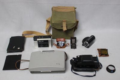 un appareil photo, un étui pour appareil photo, un appareil photo et d'autres objets disposés sur une table