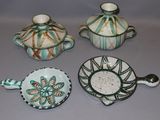 four pieces of pottery sitting on top of a table next to each other