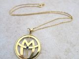 a close up of a gold necklace on a marble surface