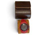 brown leather watch case with a red watch on top of it