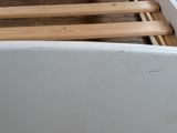 a white bathtub with wooden slats in a bathroom