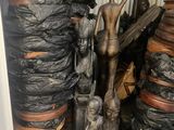 une statue représentant un homme debout à côté d'un tas de sacs noirs