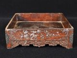 an old wooden box with a floral design on it on a black background