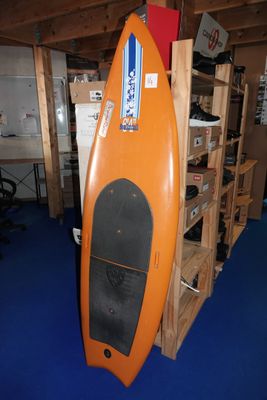 une planche de surf orange exposée dans une pièce