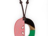 Le collier est en bois et présente un motif rouge, vert et noir.