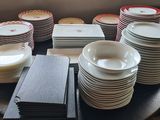 a lot of plates and bowls on the table