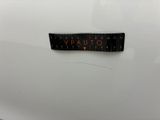 a close up of a sticker on the back of a white car