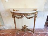 une table au plateau en marbre, surmontée d'un cadre doré