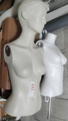 a white mannequin sitting on top of a table next to a pair of scissors