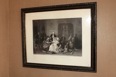 un tableau accroché au mur au-dessus des toilettes